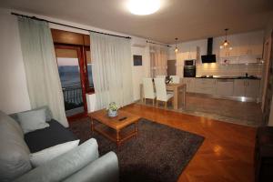 a living room with a couch and a table at Moderan apartman u blizini mora in Povile