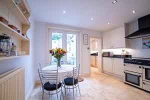 eine Küche mit einem Tisch mit einer Vase mit Blumen darauf in der Unterkunft Waterman's Cottage in Kent