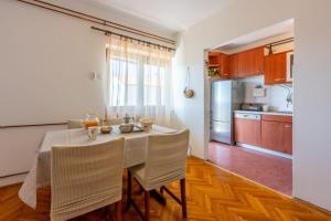 una cucina e una sala da pranzo con tavolo e sedie di Apartment Tus A2 a Crikvenica