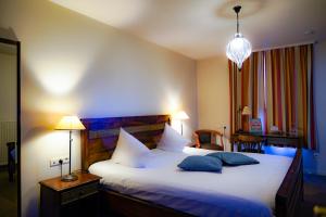 a bedroom with a large bed with two pillows at Oranje City Hotel in Diest