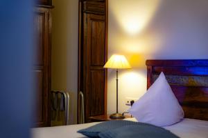 a bedroom with a bed with a lamp and a pillow at Oranje City Hotel in Diest