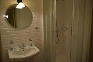 a bathroom with a sink and a shower with a mirror at Oranje City Hotel in Diest