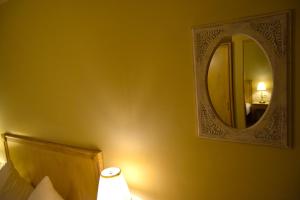 a bedroom with a mirror and a bed and a lamp at Oranje City Hotel in Diest