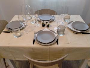 a table with plates and wine glasses and plates and napkins at Sea&Bike_Apartment in Finale Ligure