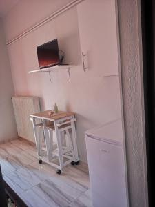 ΧΑΡΗΣ ROOMS في Kritharia: طاولة صغيرة في غرفة صغيرة مع مكتب