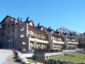 a large building with a mountain in the background at Chardín Bellvedé-Apartamentos Chardins in Cerler