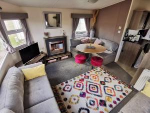 Vista aérea de una sala de estar con sofá y mesa en Newquay Caravan Holiday en Newquay