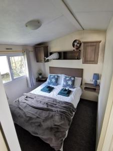 Newquay Caravan Holiday في نيوكواي: غرفة نوم بسرير في غرفة صغيرة