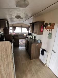 Newquay Caravan Holiday في نيوكواي: مطبخ في فرن مع دواليب خشبية