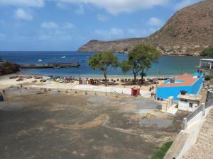 una playa con un edificio azul y un cuerpo de agua en Hotel Sol Marina, en Tarrafal