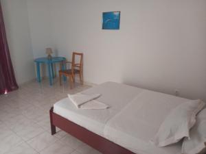 a bedroom with a bed and a table and a chair at Hotel Sol Marina in Tarrafal