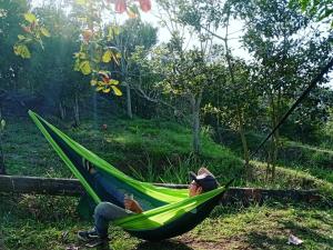 a man laying in a hammock in a field at Mini casa San Gil-Mogotes in San Gil