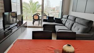 a living room with a couch and a tv at Alquiler Vacacional Salou W&S in Salou