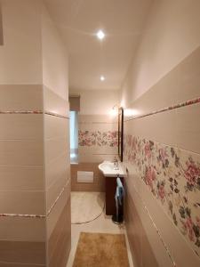 a bathroom with a sink and flowers on the wall at Verona City Arsenale Apartment in Verona