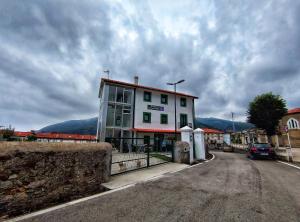 ein weißes Gebäude an der Seite einer Straße in der Unterkunft Albergue de Santullán in Castro-Urdiales