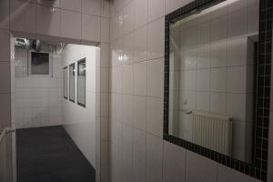 a bathroom with white tile walls and a mirror at Bett3de in Erding