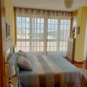 um quarto com uma cama e uma grande janela em A casa do clarete em Castro Caldelas