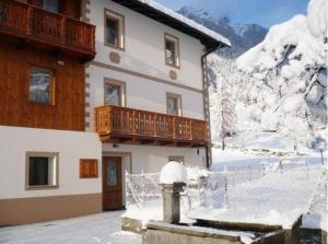 a building with a balcony and a fire hydrant in the snow at B&B Il Sorriso Dei Nonni in Pracorno di Rabbi