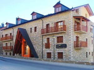 un gran edificio de ladrillo con techo negro en Chardín Bellvedé-Apartamentos Chardins, en Cerler