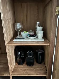 a wooden shelf with bowls and a wine glass at Dahli's Sleep Boutique in Amsterdam