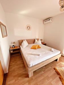 a bedroom with a bed with white sheets and wooden floors at The Manzoni family 5 in Punat