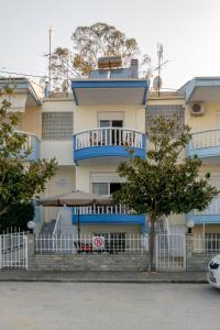 ein blau-weißes Gebäude mit einem Balkon in der Unterkunft Just on the Sea 2 in Nea Iraklitsa