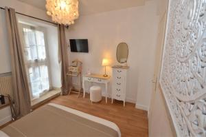 迪南Demeures & Châteaux - Hôtel de la porte Saint-Malo - DINAN的带床、梳妆台和镜子的卧室