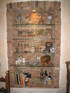 una chimenea de ladrillo con estanterías y copas de vino en Dalla Magna Livia L&L, en Brusasco
