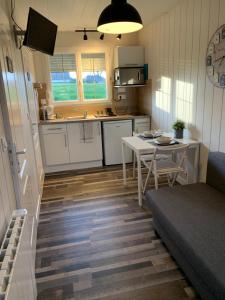 een keuken en een woonkamer met een tafel en een bank bij Resid Home 5 - Duplex cosy avec parking gratuit in Saint-Léonard