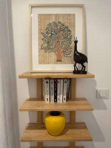 a book shelf with a yellow vase and a picture at Joli gîte à Chéroy in Chéroy