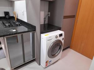 a kitchen with a washing machine and a stove at Apartamento bem localizado in Bento Gonçalves