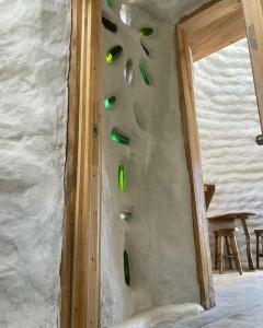 uma parede de pedra com garrafas verdes na parede em Ecodomos La Tongoycilla em Guanaqueros