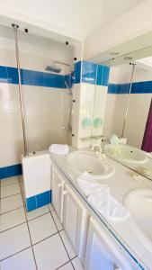 a bathroom with two sinks and a tub and a mirror at Hôtel Bois Joli in Terre-de-Haut