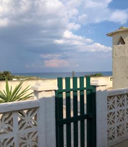 a green gate in front of the beach at LuGa Apartments in Campomarino