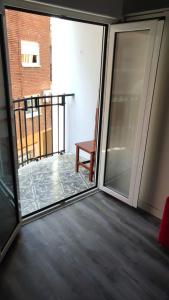 a sliding glass door with a chair on a balcony at King's Pawn in Chirivella