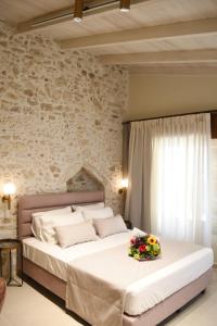 Un dormitorio con una cama grande con flores. en Philikon Luxury Suites en Rethymno