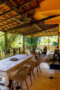 un patio con tavolo e sedie su un ponte di Guest House Fazenda do Francês & Culinária Francesa a Cachoeiras de Macacu
