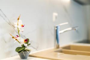 a small vase with a flower on a bathroom sink at TwinStars Wonderful View in Kalyves Poligirou +39 photos