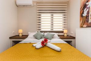 a bedroom with a bed with a yellow blanket at TwinStars Wonderful View in Kalyves Poligirou