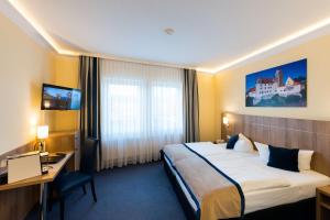 una camera d'albergo con letto e scrivania di Askania Hotel & Brauhaus a Bernburg