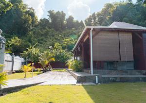een huis met een veranda en een grasveld bij La Savannah Villa in Labuthie