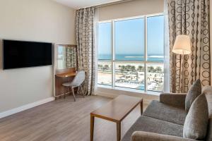 uma sala de estar com um sofá e uma grande janela em Radisson Resort Ras Al Khaimah Marjan Island em Ras al-Khaimah