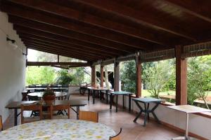 un restaurante con mesas, sillas y ventanas en Agriturismo Gavina Pes, en Campanedda