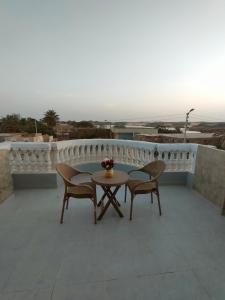um pátio com 2 cadeiras e uma mesa na varanda em Abu simbel Nubian Guest House em Abu Simbel