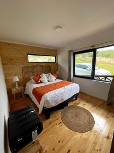 1 dormitorio con cama y ventana grande en Moon River Puerto Varas en Puerto Varas