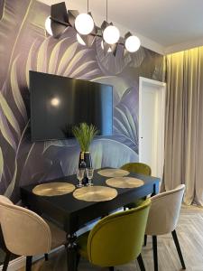 jadalnia z czarnym stołem i krzesłami w obiekcie Family & Business Sauna Tężnia Apartments No18 Leśny nad Zalewem Cedzyna -1 Bedroom with Private Sauna, Bath with Hydromassage , Terrace, Parking, Catering Options w Kielcach