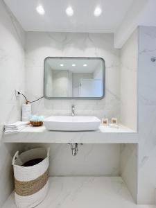 a white bathroom with a sink and a mirror at Nostos home in Dhragoulás