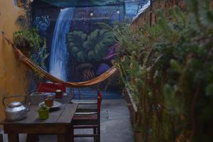 a patio with a table and a waterfall mural at HOPA-Home Patagonia Hostel in San Carlos de Bariloche