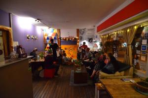 HOPA-Home Patagonia Hostel & Bar في سان كارلوس دي باريلوتشي: مجموعة من الناس يجلسون في غرفة