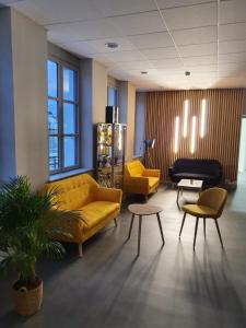 ein Wohnzimmer mit einem gelben Sofa sowie Tischen und Stühlen in der Unterkunft Résidence Musicale Haut 2 Gammes - Gîte in Saint-Hippolyte